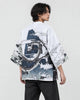 Man in the white haori seen from behind at an angle, with a coiling gray dragon and black and white waves, over a black tee