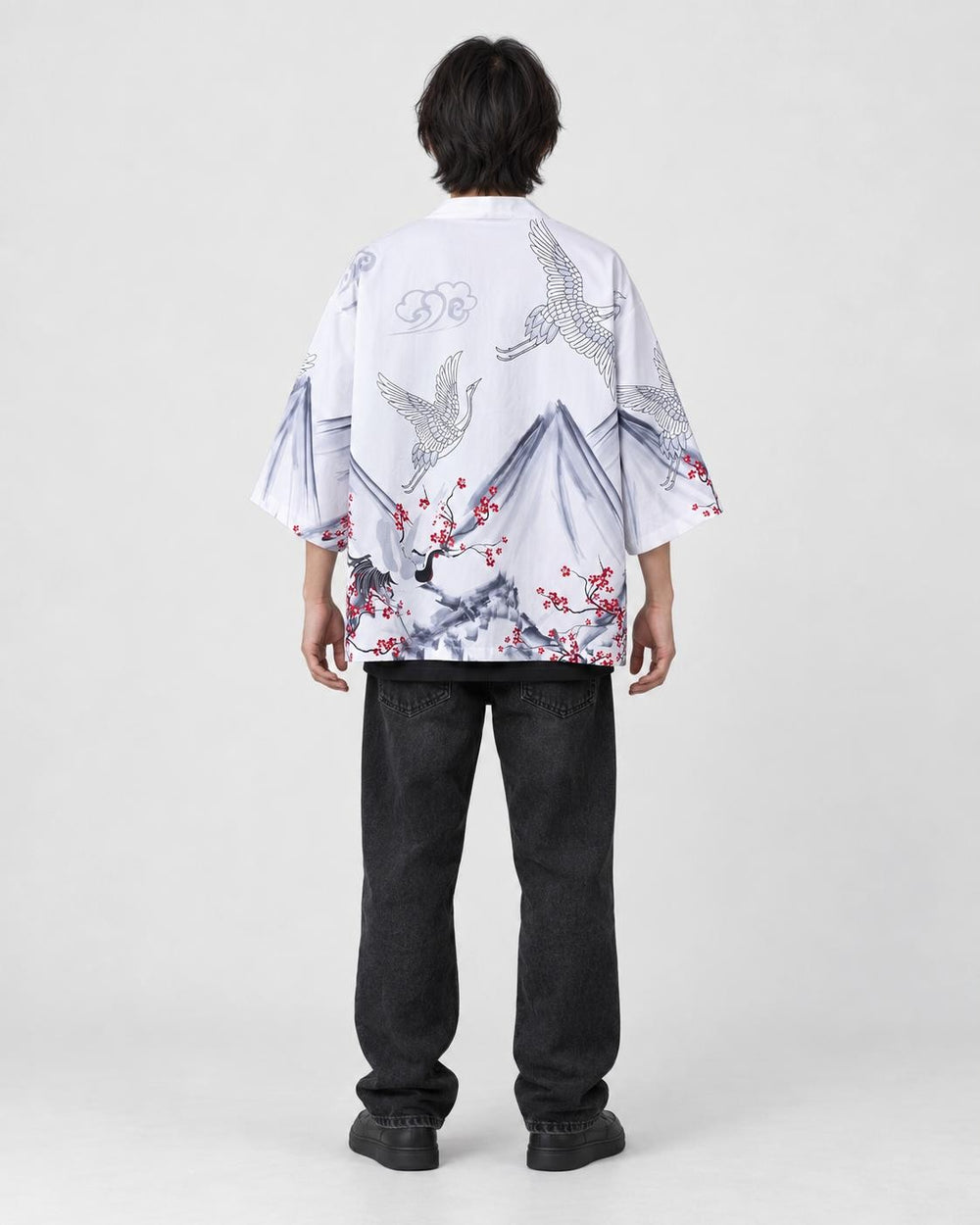 Full-length back view of a man in the white haori with gray mountains, white cranes and red plum blossoms, black jeans