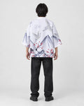 Full-length back view of a man in the white haori with gray mountains, white cranes and red plum blossoms, black jeans