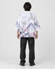 Full-length back view of a man in the white haori with gray mountains, white cranes and red plum blossoms, black jeans