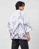 Man in the white haori seen from behind at an angle, with gray mountains, white cranes and red plum blossoms, black tee
