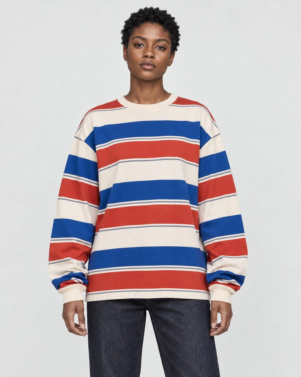 Model wearing the red striped crewneck sweatshirt with dark jeans, front view