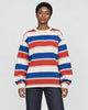 Model wearing the red striped crewneck sweatshirt with dark jeans, front view