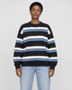Model wearing the black striped knit sweater with light-wash jeans, front view