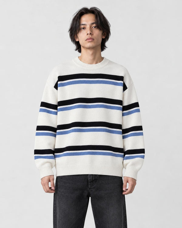 Model wearing the white striped knit sweater with dark jeans, front view