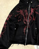 Close-up of the red winged dragon graphic and the zipper on the black hoodie