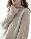 Beige woven-knit sweater with a ribbed mock neck, one hand raised to the collar and the wide sleeve falling loose