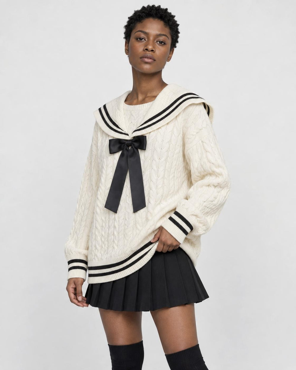 Woman in the cream sailor-collar cable-knit sweater and black skirt, three-quarter view