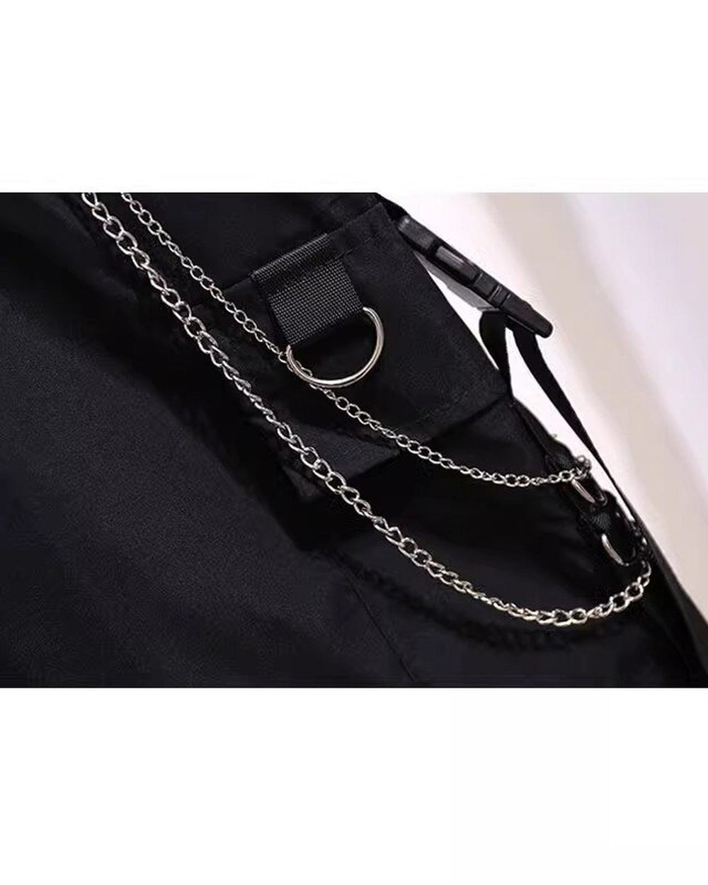 Close view of the silver chain and the strap pocket with a D-ring on the black cargo shorts