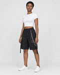 Woman in the black chain cargo shorts turned slightly, showing the pocket, chain and hanging strap
