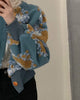 Close view of the raised yellow and pale blue flower patches on the teal jacket
