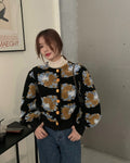 Woman standing in the black flower-patch jacket with a phone in her hand