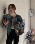 Woman standing in the teal flower-patch jacket with a brown shoulder bag