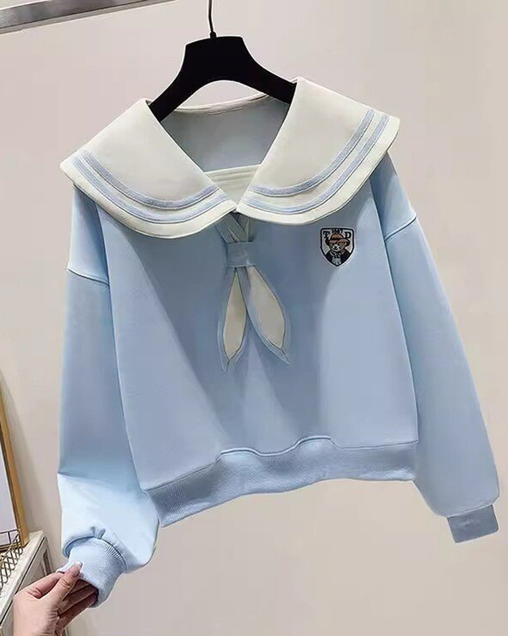 Light blue sailor-collar sweatshirt on a hanger, showing the puffed sleeve and the ribbed cuff