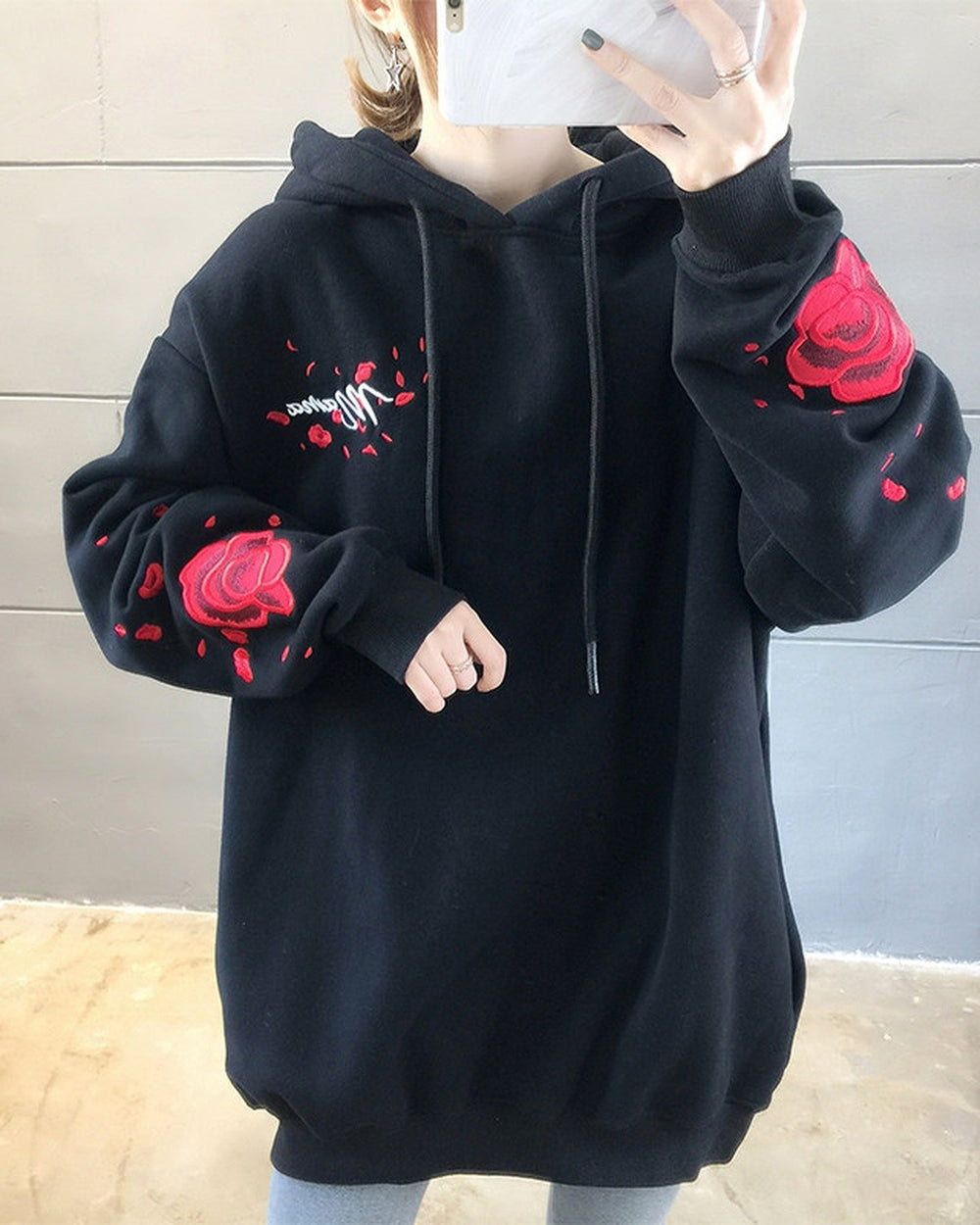 Black loose hooded sweatshirt with embroidered red roses on the sleeves, front view
