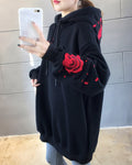 Close-up of the embroidered red rose and petals on a black hoodie sleeve