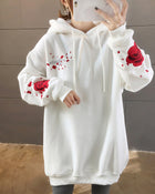 White loose hooded sweatshirt with embroidered red roses on the sleeves, front view