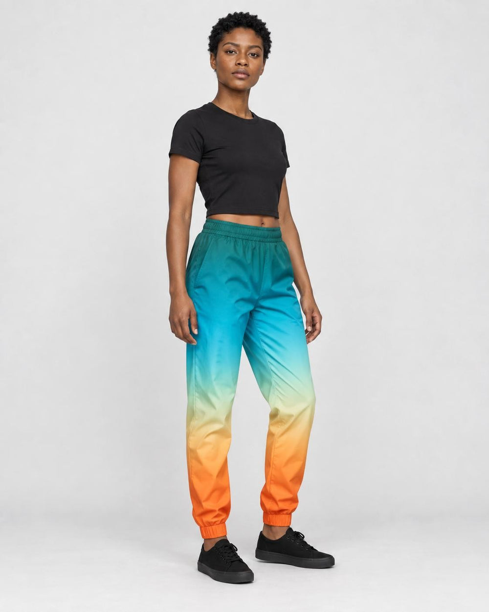 Woman in the teal to orange gradient joggers turned slightly, showing the fade and the gathered cuffs