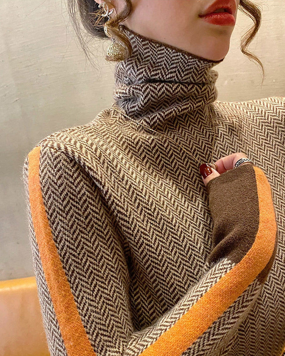Brown and cream herringbone turtleneck with an orange stripe down the sleeve, torso view