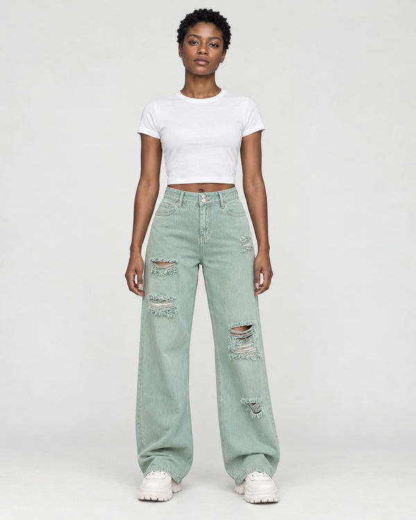 Woman in mint-green ripped wide-leg jeans with a white cropped tee and white platform sneakers, full length
