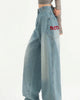 Light-blue wide-leg jeans with a large thigh pocket and red embroidered REN lettering, worn standing