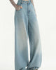 Light-blue wide-leg jeans with one hand in the pocket, showing the straight wide leg to the floor