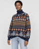 Model wearing the navy jacquard knit sweater with bunny and smiley face rows and a brown lettering band, with light jeans