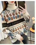Cream high-neck jacquard knit sweater, front view, with orange mushroom trees and large blue figures above the hem