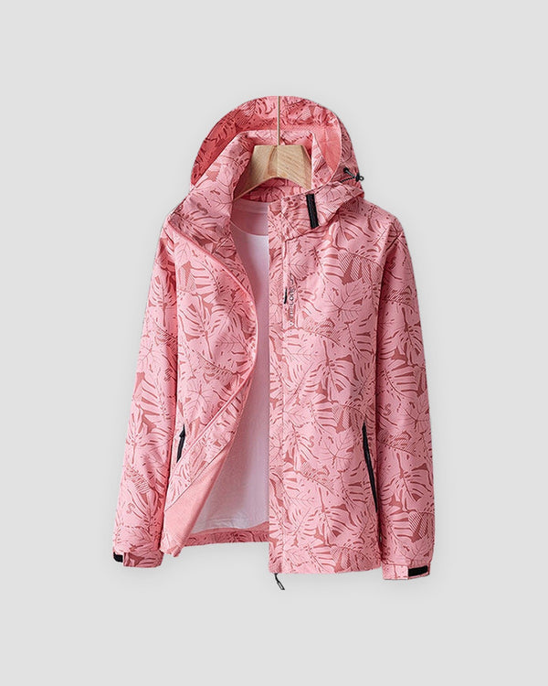 Pink leaf-print hooded windbreaker with a black collar tab and hook-and-loop cuffs, shown on a hanger
