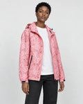 Model wearing the pink leaf-print hooded windbreaker open over a white tee and black jeans, three-quarter view