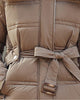 Close-up of the tie belt with a tortoiseshell-look buckle and the snapped belt loops on the puffer coat