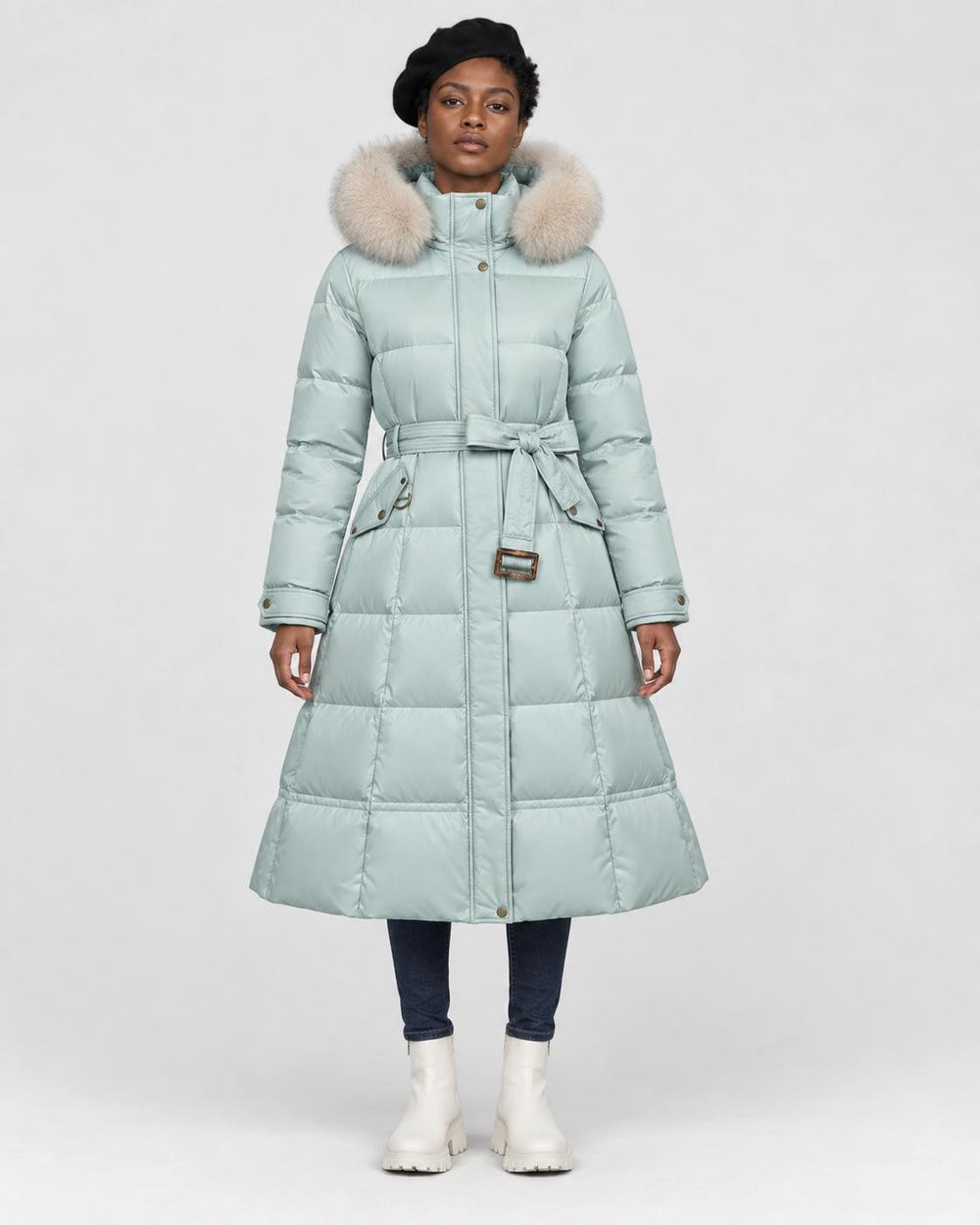 Model wearing the mint long puffer coat with a khaki fluffy hood trim and a tie belt, front view