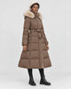 Model wearing the coffee brown long puffer coat with a khaki fluffy hood trim and a tie belt, three-quarter view