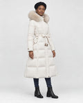 Model wearing the white long puffer coat with a khaki fluffy hood trim and a tie belt, three-quarter view