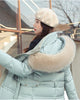 Mint puffer coat from the side, showing the khaki hood trim, the belt and a snapped flap pocket