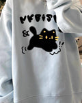 Light blue loose sweatshirt with a black cat print, worn loose, front view