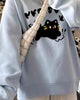 Light blue loose sweatshirt with a black cat print, side view of the sleeve