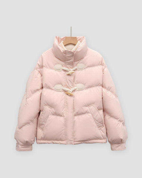 Pink short puffer jacket with chevron quilting, a stand collar and two horn toggles on cord loops, on a hanger