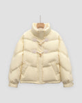 Pale yellow short puffer jacket with chevron quilting and two horn toggles on cord loops, on a hanger