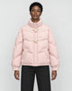 Woman in a short pink puffer jacket with horn toggles over a black top and black trousers, torso to mid-thigh