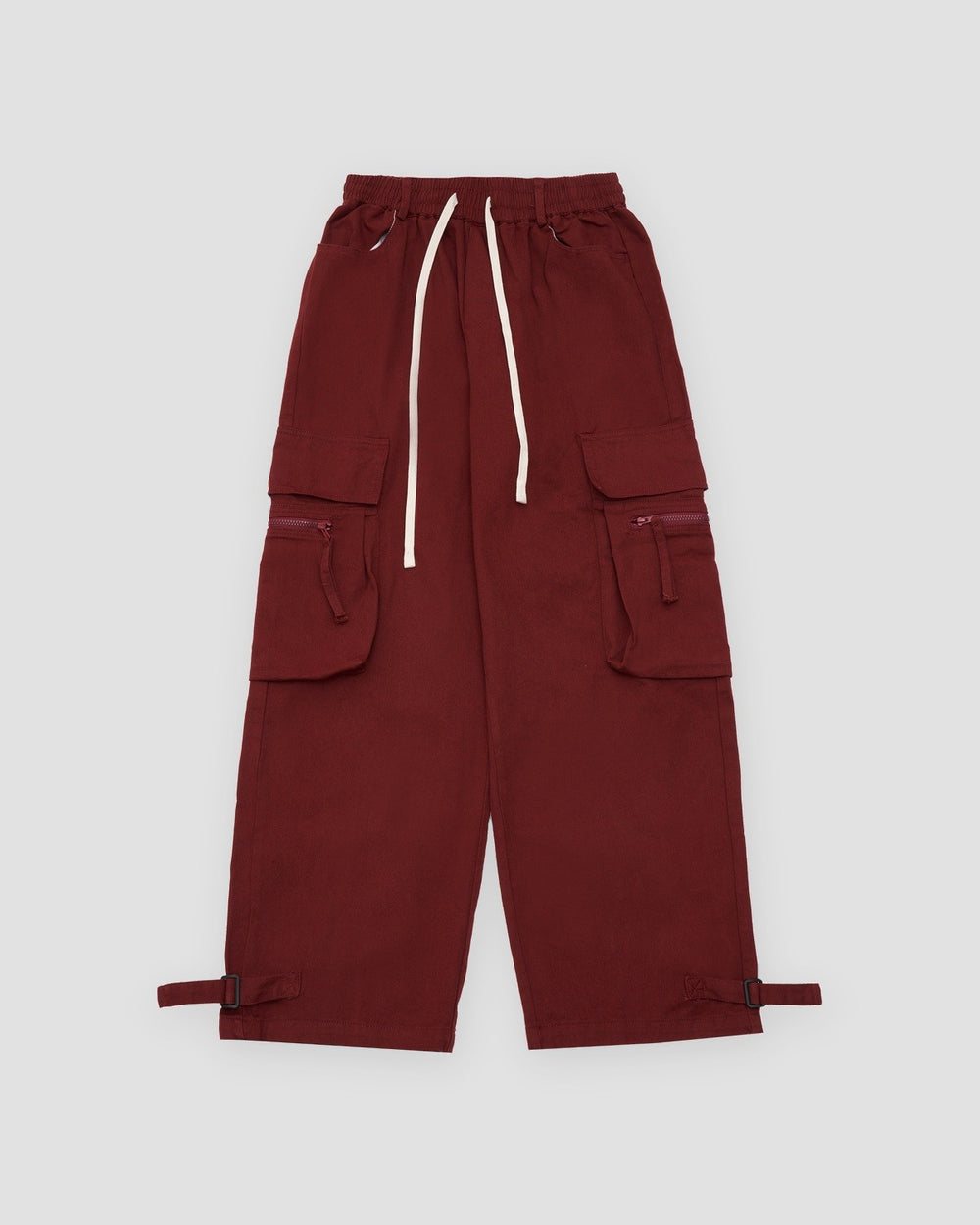 Maroon red wide-leg cargo pants laid flat with thigh flap pockets, a cream drawcord and ankle straps