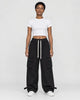 Woman in black wide-leg cargo pants with flap pockets, a white cropped tee and white sneakers, full length