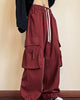 Side view of the maroon red cargo pants with a large flap pocket and zip pocket on the thigh