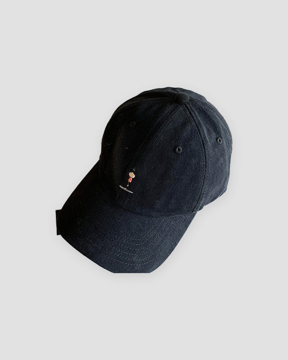 Black baseball cap with a tiny embroidered yoga figure, three-quarter view