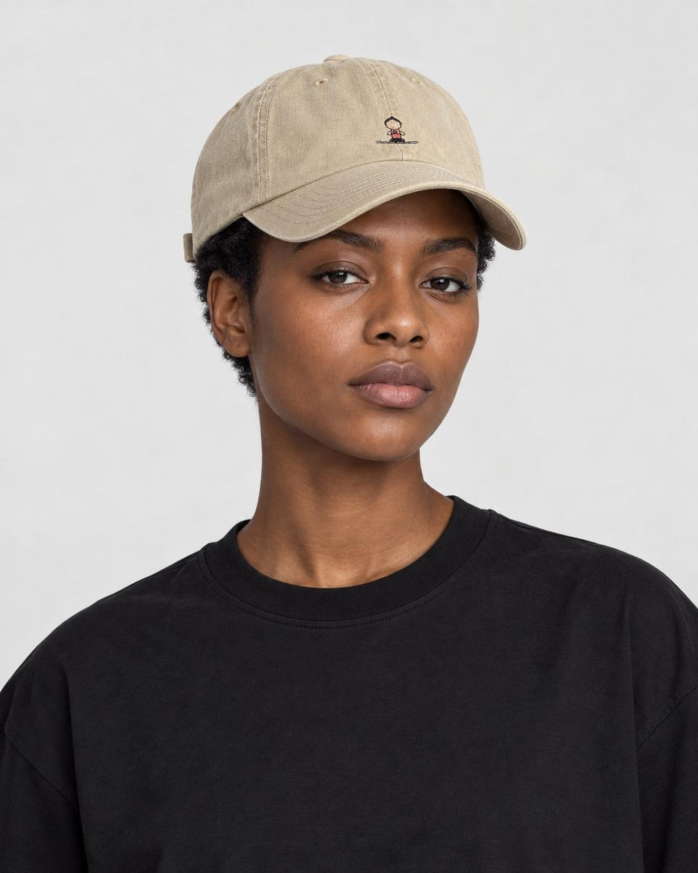 Model wearing the khaki yoga embroidered baseball cap with a black tee, side view