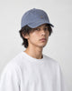 Model wearing the blue gray yoga embroidered baseball cap with a white tee, three-quarter view