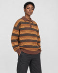 Model wearing the knit polo sweater with black jeans, three-quarter view