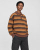 Model wearing the knit polo sweater with black jeans, three-quarter view