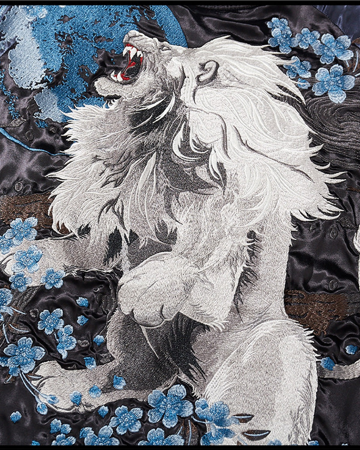 Close-up of the Lion and Blossom jacket’s embroidered white lion and blue flowers